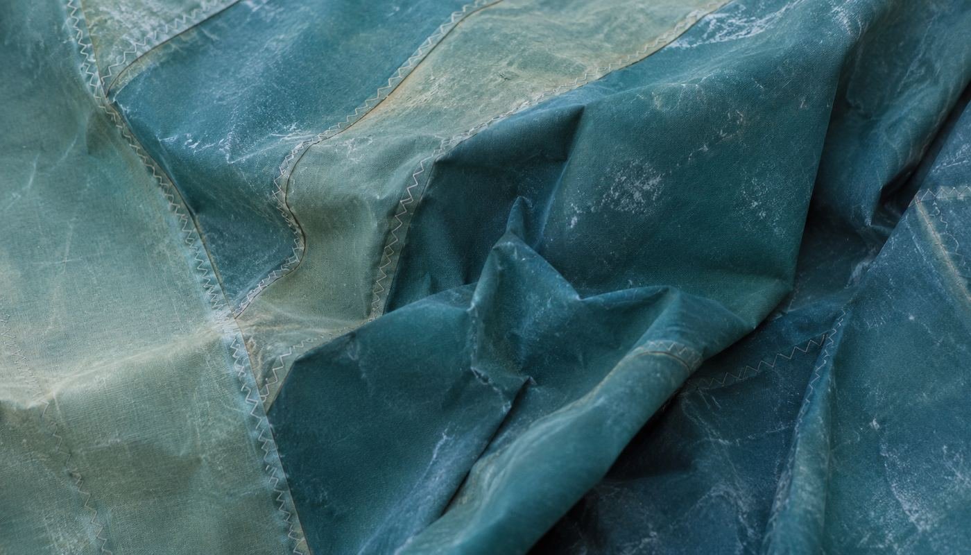 Voile de bateau usée et froissée, camaïeu de bleu et de vert glaz